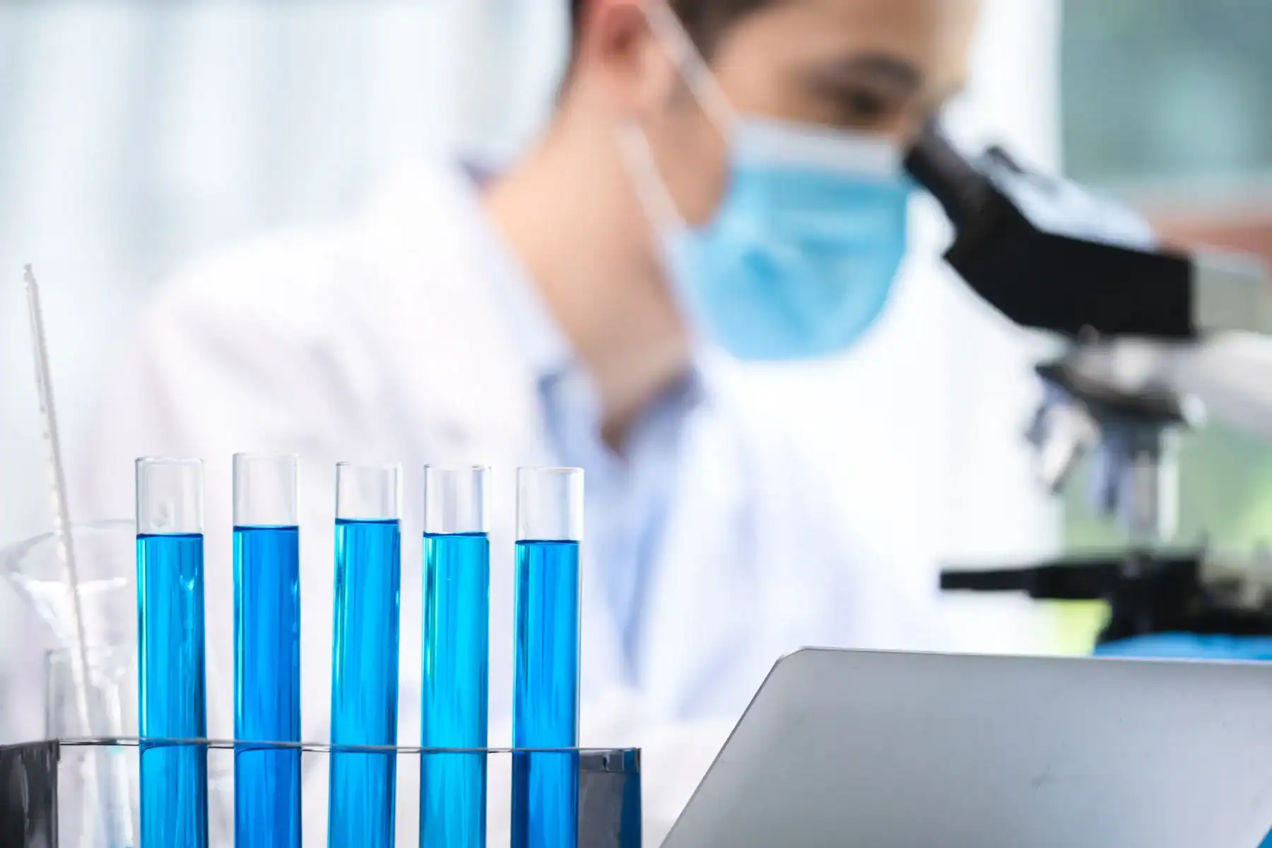 Laboratory professional reviewing samples beside analytical equipment.